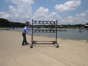 An employee pushing a rack and rafters outside.